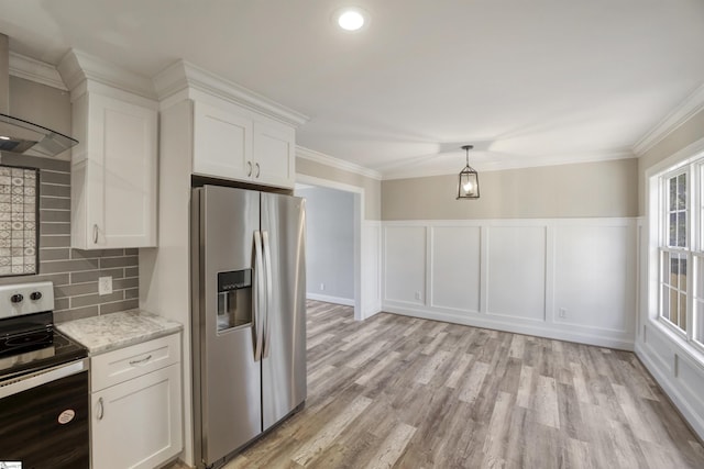 kitchen with appliances with stainless steel finishes, white cabinets, backsplash, crown molding, and wall chimney exhaust hood