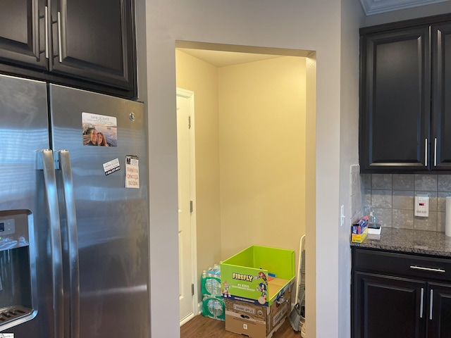 kitchen featuring stainless steel fridge with ice dispenser, decorative backsplash, dark wood-type flooring, and dark stone counters