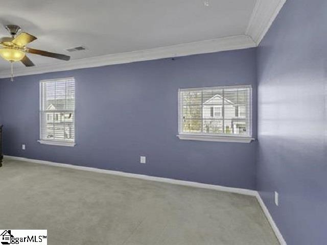 spare room featuring crown molding, carpet flooring, and ceiling fan