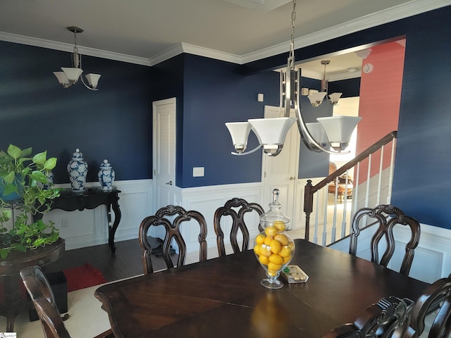 dining area with ornamental molding, hardwood / wood-style floors, and a notable chandelier