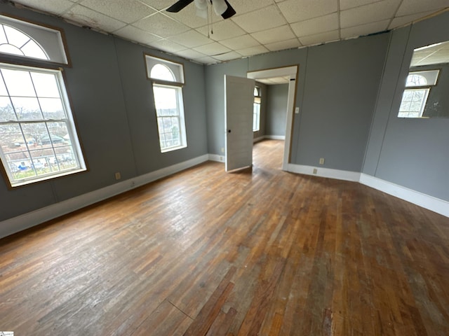 unfurnished room featuring dark wood-type flooring, a paneled ceiling, and ceiling fan