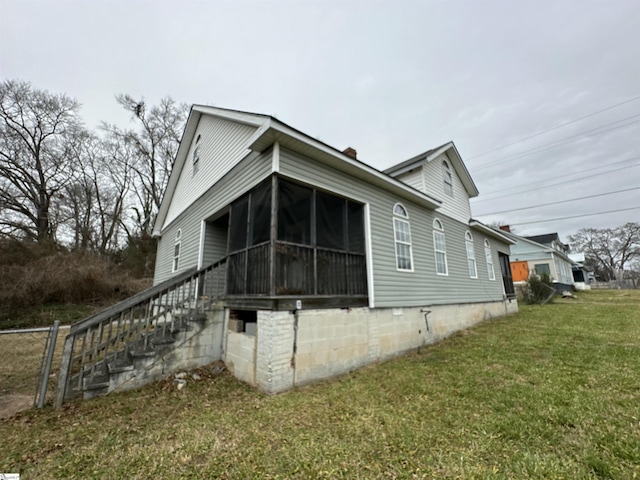 view of home's exterior featuring a yard and a sunroom