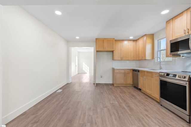 kitchen with appliances with stainless steel finishes, sink, decorative backsplash, light hardwood / wood-style floors, and light brown cabinets