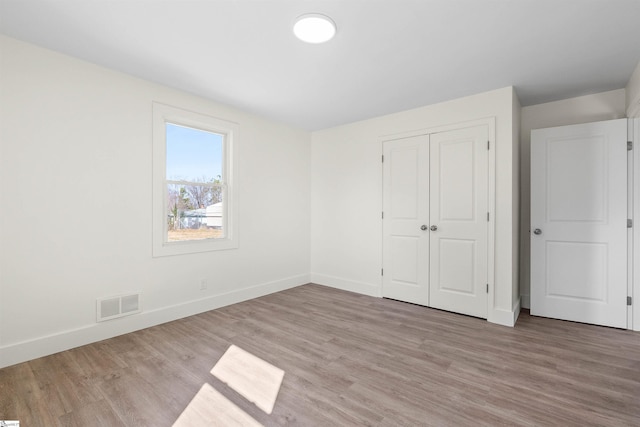 unfurnished bedroom with a closet and light hardwood / wood-style flooring