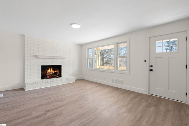 unfurnished living room featuring a fireplace and light wood-type flooring