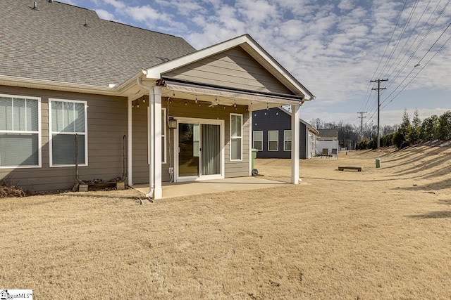 rear view of house with a yard and a patio