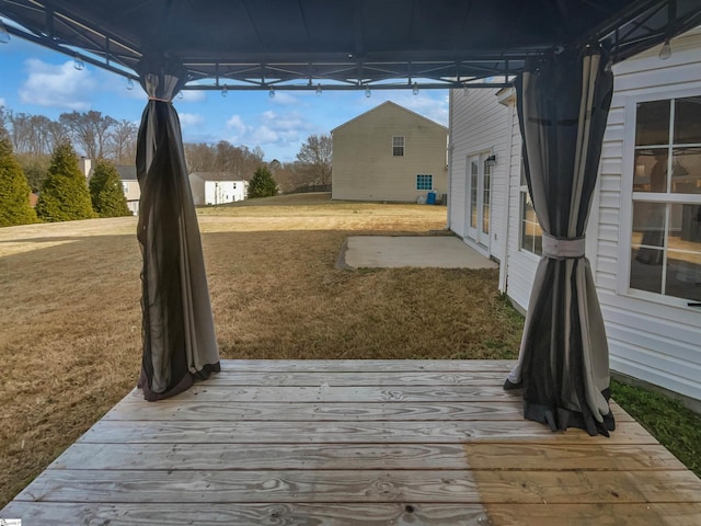 wooden terrace featuring a lawn