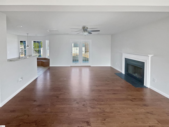 unfurnished living room featuring dark hardwood / wood-style flooring and ceiling fan