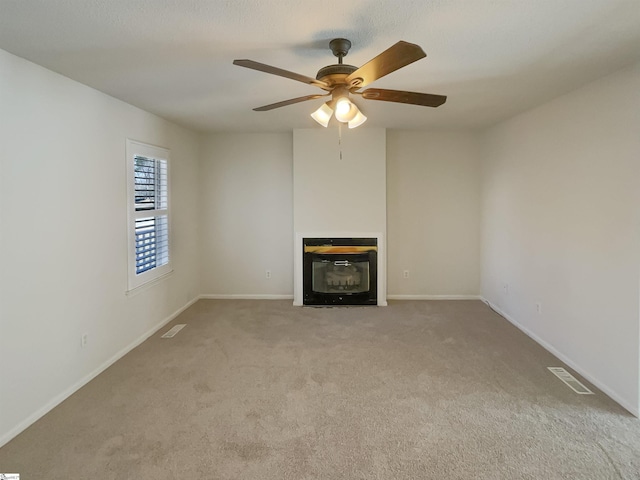 unfurnished living room featuring light carpet and ceiling fan