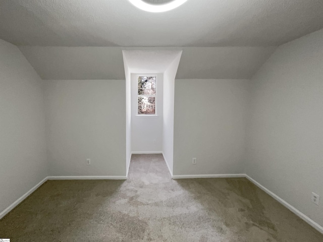 bonus room with lofted ceiling, a textured ceiling, and carpet flooring