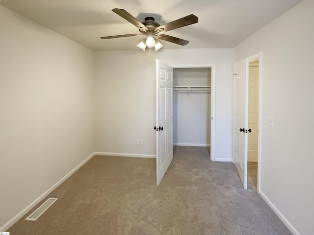 unfurnished bedroom with ceiling fan, a closet, and light carpet