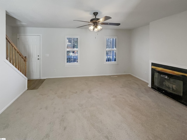 unfurnished living room with light carpet and ceiling fan