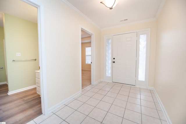 tiled foyer featuring crown molding