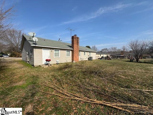 back of property featuring a lawn