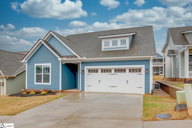 craftsman inspired home featuring a garage, a front yard, and central air condition unit