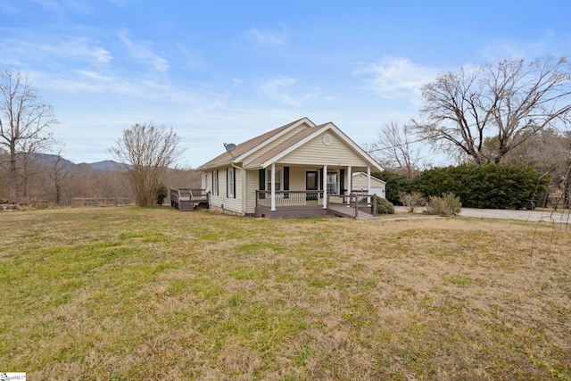 view of front of property featuring a mountain view, covered porch, and a front lawn