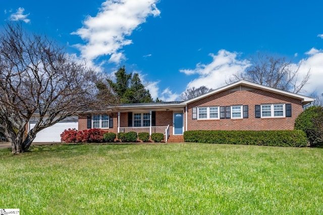 ranch-style home featuring a garage, covered porch, and a front lawn