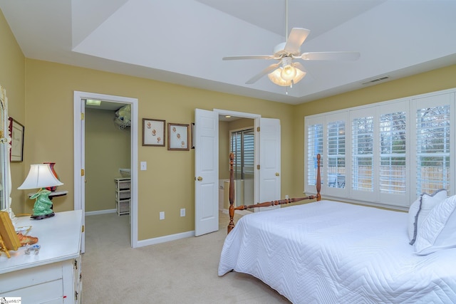 carpeted bedroom with a walk in closet, ceiling fan, and a closet