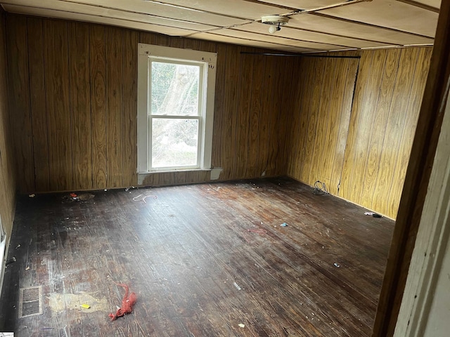 unfurnished room featuring dark hardwood / wood-style floors and wood walls