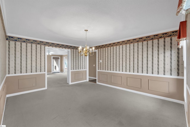 unfurnished dining area with crown molding, carpet floors, and ceiling fan with notable chandelier