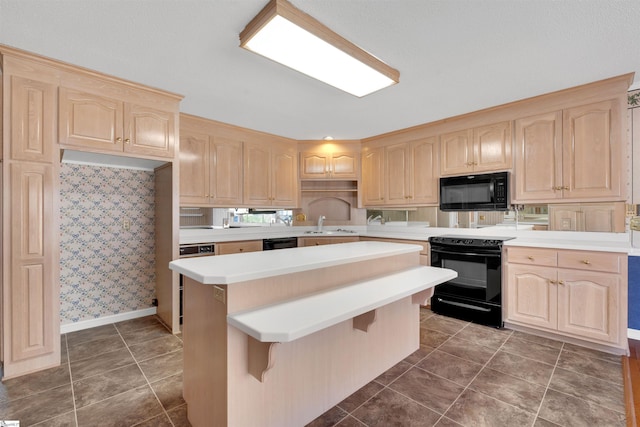 kitchen with sink, a kitchen breakfast bar, a center island, black appliances, and light brown cabinetry