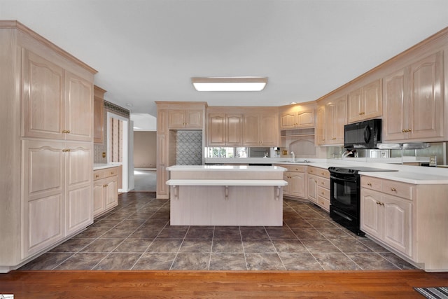 kitchen with light brown cabinetry, sink, tasteful backsplash, a center island, and black appliances
