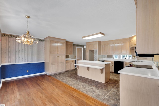 kitchen with black appliances, decorative light fixtures, and light brown cabinets