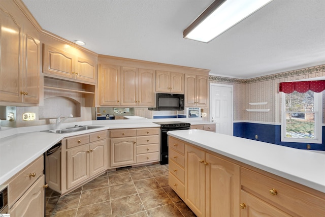 kitchen featuring light brown cabinetry, sink, and black appliances