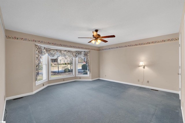 unfurnished room with dark colored carpet, a textured ceiling, and ceiling fan
