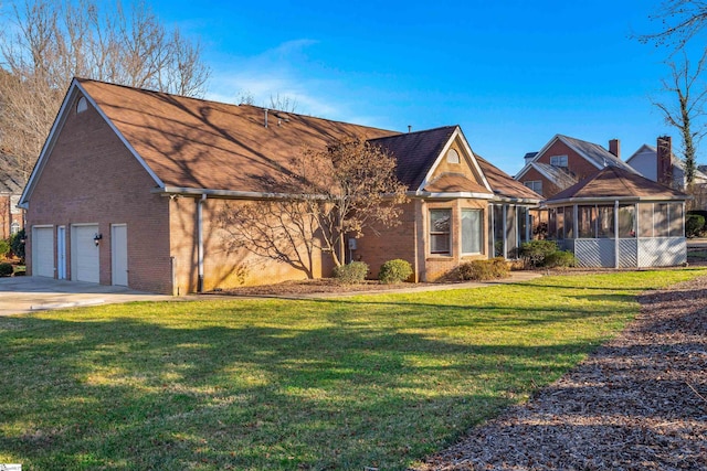 view of front of home with a garage, a sunroom, and a front yard
