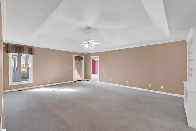 unfurnished room with carpet floors, a textured ceiling, ceiling fan, and a tray ceiling