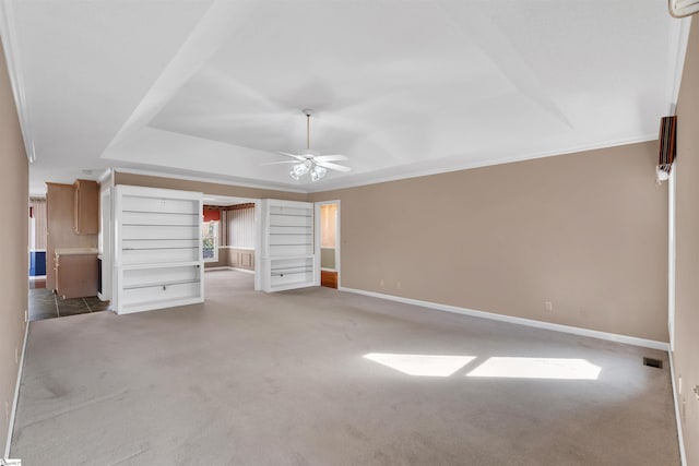 unfurnished bedroom featuring light carpet, crown molding, a raised ceiling, and ceiling fan