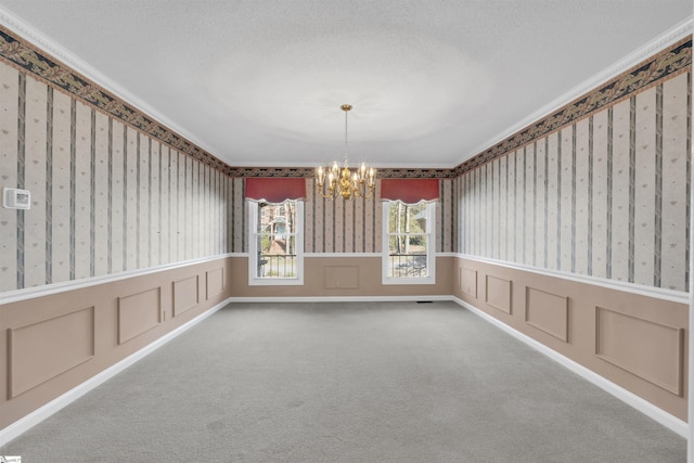 spare room with carpet floors, a textured ceiling, and a chandelier