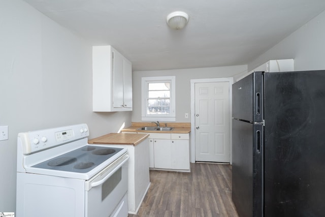 kitchen featuring white electric range, white cabinetry, sink, black fridge, and dark wood-type flooring