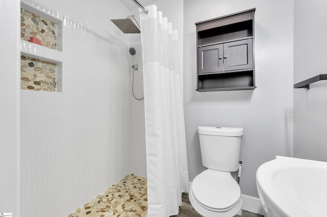 bathroom featuring walk in shower and toilet