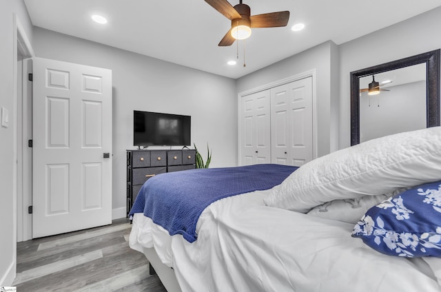 bedroom featuring hardwood / wood-style floors, a closet, and ceiling fan