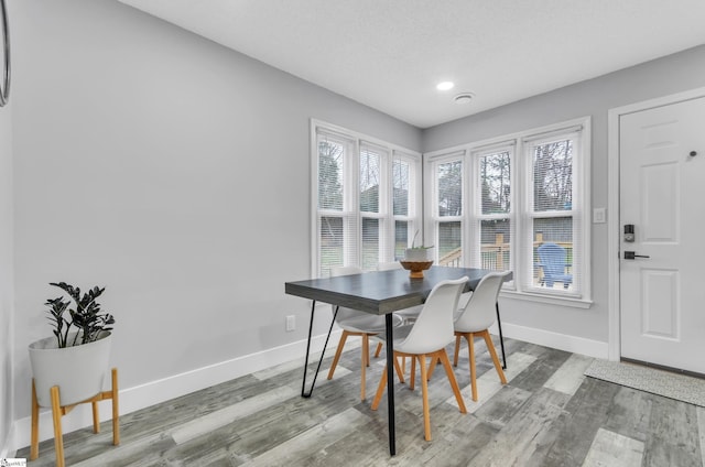 dining space featuring hardwood / wood-style flooring and a textured ceiling