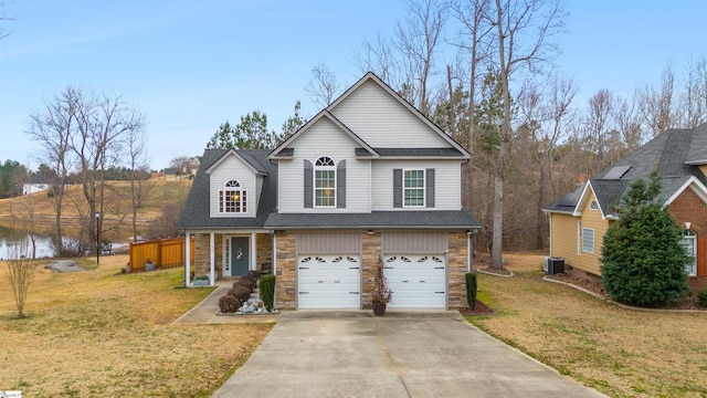 view of front facade featuring a garage, a water view, central AC unit, a front yard, and covered porch