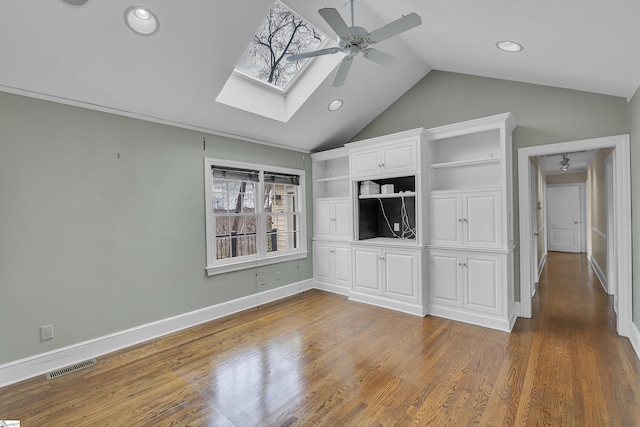 unfurnished living room featuring hardwood / wood-style flooring, lofted ceiling with skylight, and ceiling fan