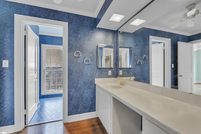 bathroom with vanity, hardwood / wood-style floors, crown molding, and ceiling fan