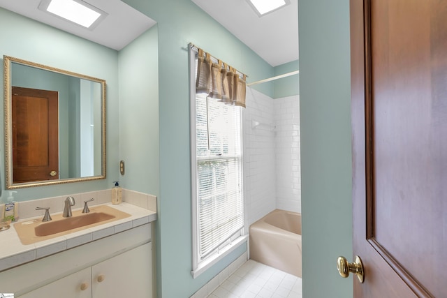 bathroom featuring tiled shower / bath combo, vanity, and tile patterned floors