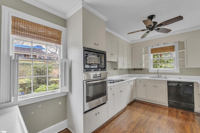 kitchen featuring sink, crown molding, wood-type flooring, black appliances, and white cabinets