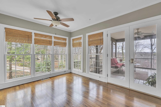 unfurnished sunroom with ceiling fan