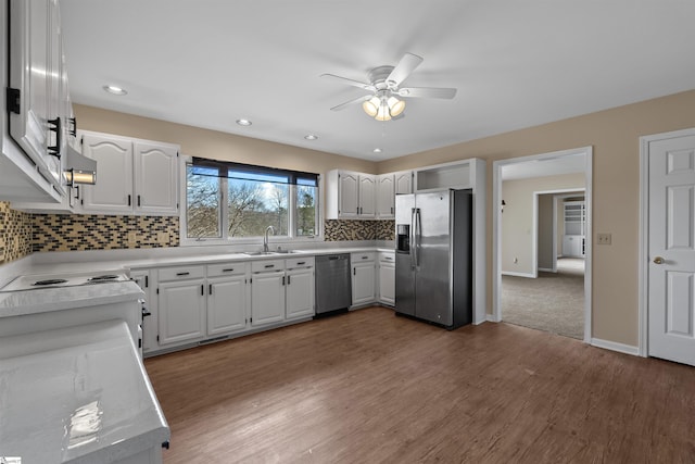 kitchen featuring dark wood-type flooring, appliances with stainless steel finishes, sink, and white cabinets