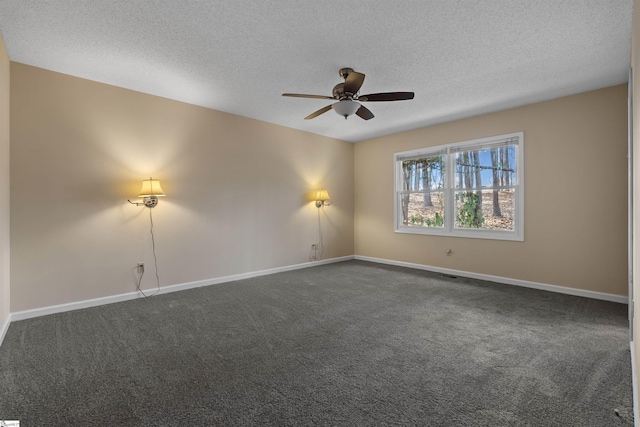 empty room with ceiling fan, a textured ceiling, and dark colored carpet