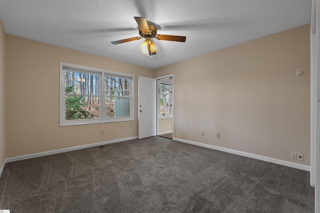 carpeted empty room featuring ceiling fan and a textured ceiling