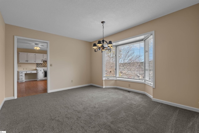 carpeted empty room featuring ceiling fan with notable chandelier and a textured ceiling