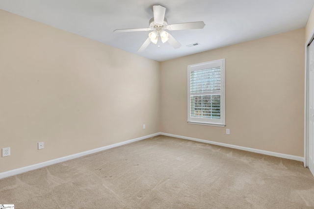 spare room with ceiling fan and light colored carpet
