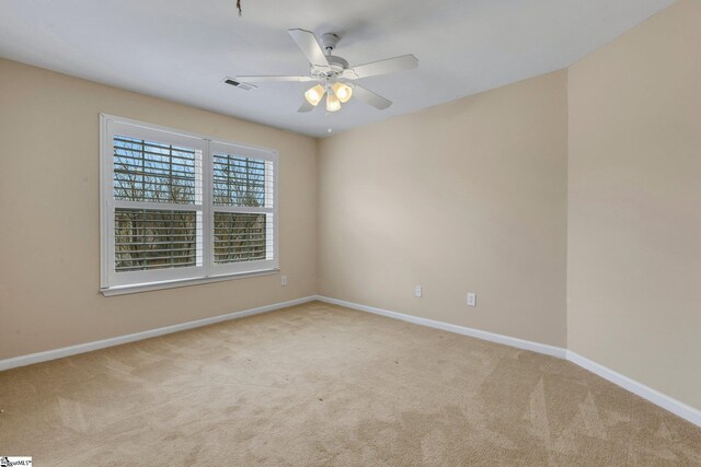 spare room featuring light colored carpet and ceiling fan