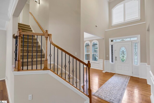 entrance foyer featuring wood-type flooring and a high ceiling